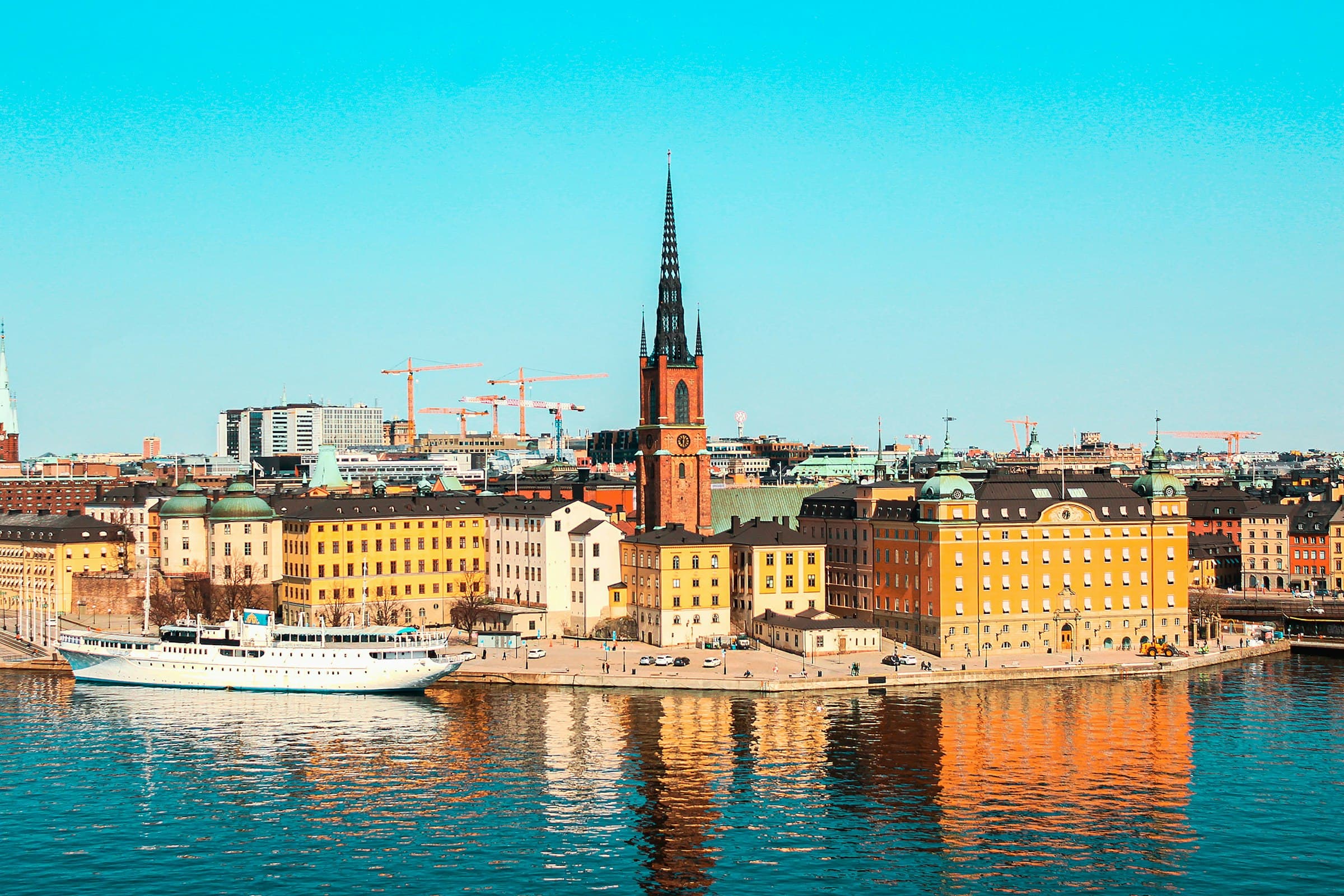 Stockholm's waterfront at dusk, a boat moored in front of the old town's facades